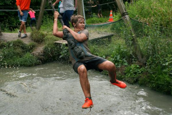 jongen slingert boven water