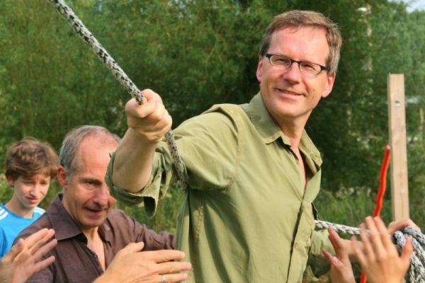 man met touw tijdens actief familie uitje in de natuur