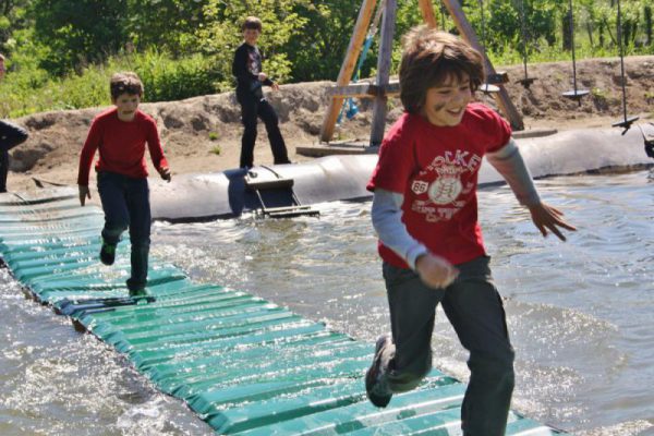 jongens rennen over watermat