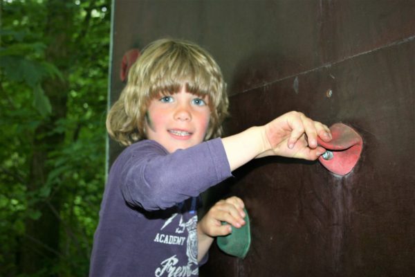 jongen op klimwand tijdens kinderfeestje