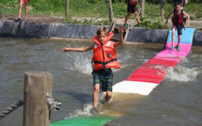 jongen met zwemvest loopt over watermat