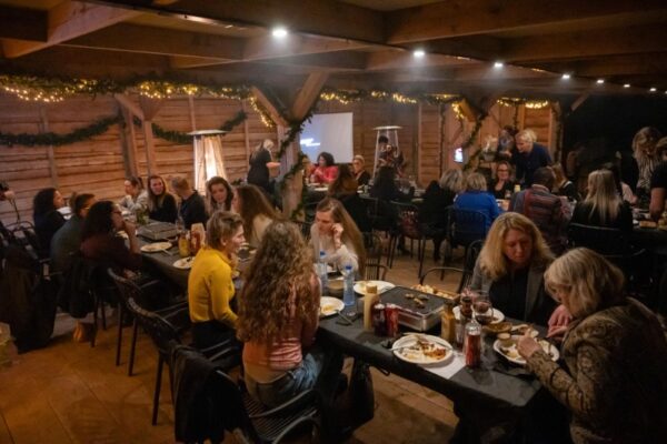 gezellige-bedrijfswinterborrel-almere-boshut - Outdoorpark SEC Almere Collega's genieten van een gezellige winterborrel met eten en drinken in een verwarmde, rustieke setting in Almere