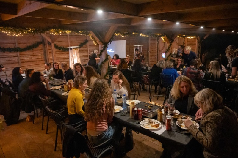 gezellige-bedrijfswinterborrel-almere-boshut - Outdoorpark SEC Almere Collega's genieten van een gezellige winterborrel met eten en drinken in een verwarmde, rustieke setting in Almere