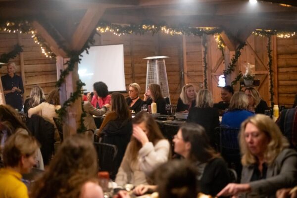 sfeervolle-bedrijfsborrel-locatie - Outdoorpark SEC Almere Gasten genieten van een sfeervolle bedrijfsborrel of winterevenement in een rustieke, met lampjes versierde evenementenruimte.
