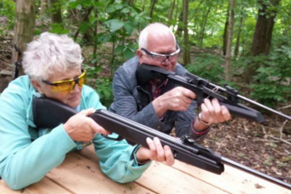 Man en vrouw met geweer tijdens schietworkshop op familiedag