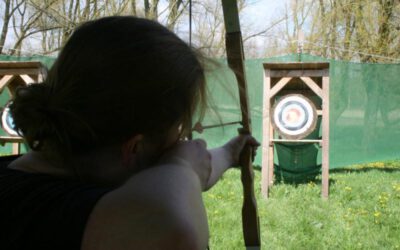 vrouw richt op de roos met boogschieten