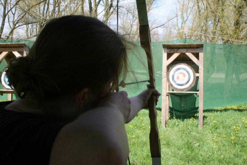 vrouw richt op de roos met boogschieten