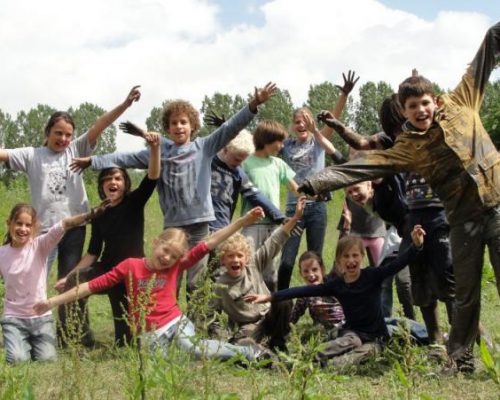 groep kinderen juichend tijdens schoolreisje in Flevoland