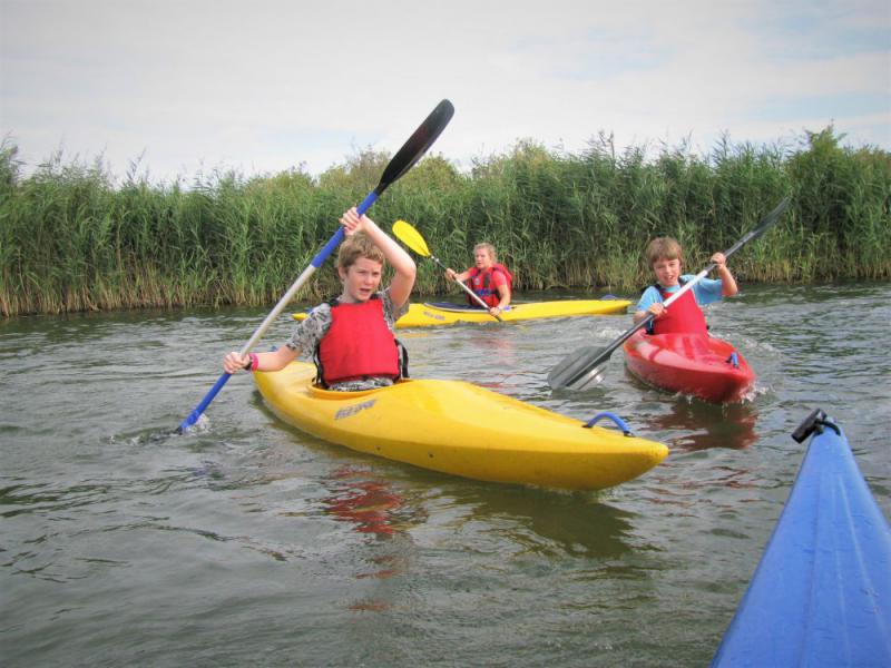 Kinderen in kayak tijdens watersport schoolreisje in Almere