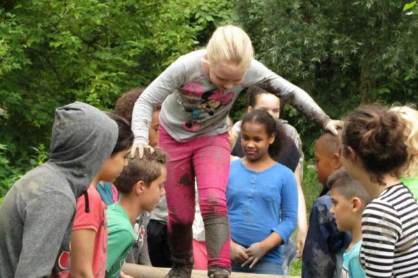 Kinderen op lopende brug in schoolreisje Almere