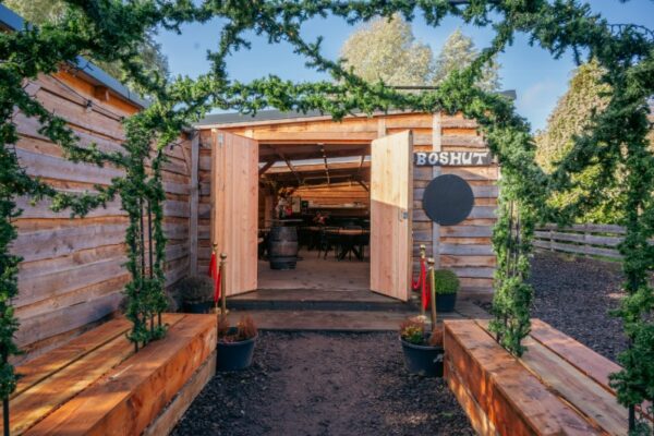 Sfeervolle entree van de Boshut bij Outdoorpark Almere, een unieke vergaderlocatie in de natuur